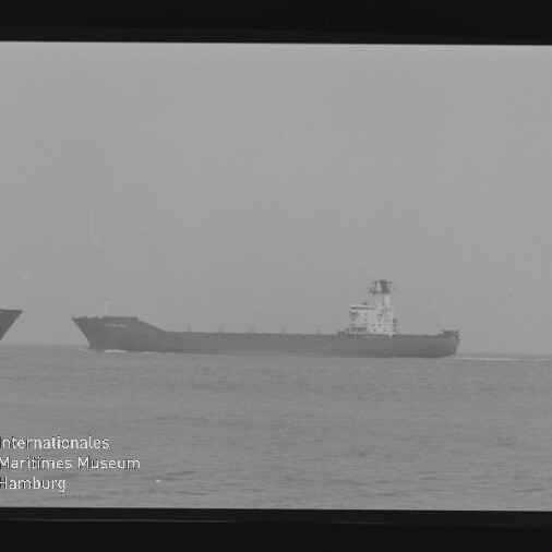 Schwarzweißfoto zweier Frachtschiffe auf ruhiger See bei diesigem Horizont, rechts ein vollständig sichtbares Tankschiff, links nur der Bug eines weiteren Schiffes; Filmrand und Stempel des Internationalen Maritimen Museums Hamburg sind sichtbar.