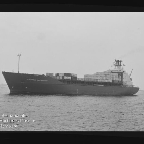 Schwarzweiß-Seitenaufnahme eines beladenen Containerschiffs mit aufgetürmten Containern auf ruhiger See; am Bug ist der Schriftzug „COLUMBUS CANTERBURY“ sichtbar und unten links ein Wasserzeichen des Internationalen Maritimen Museums Hamburg.