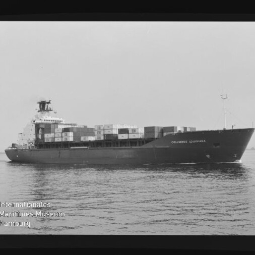 Schwarzweiß-Foto eines Containerschiffs „COLUMBUS LOUISIANA“ in Seitenansicht auf ruhiger See, mit gestapelten Containern auf dem Deck, sichtbarem Filmrand und Wasserzeichen des Internationalen Maritimen Museums Hamburg.