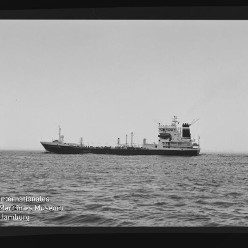 Schwarzweiß-Seitenansicht eines Tankschiffs auf ruhiger See mit Aufbauten achtern; Filmrand (u. a. Schriftzug AGFAPAN 100) und Wasserzeichen des Internationalen Maritimen Museums Hamburg sichtbar.