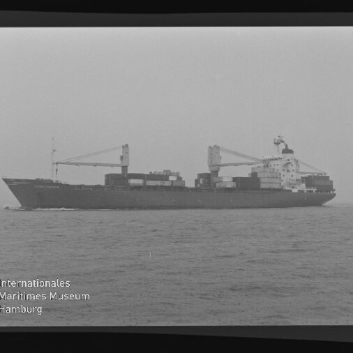 Schwarzweiß-Seitenansicht eines Containerschiffs mit aufgestapelten Containern und zwei Ladekränen, das bei ruhiger See von links nach rechts fährt; unten links Logo und Schriftzug des Internationalen Maritimen Museums Hamburg.