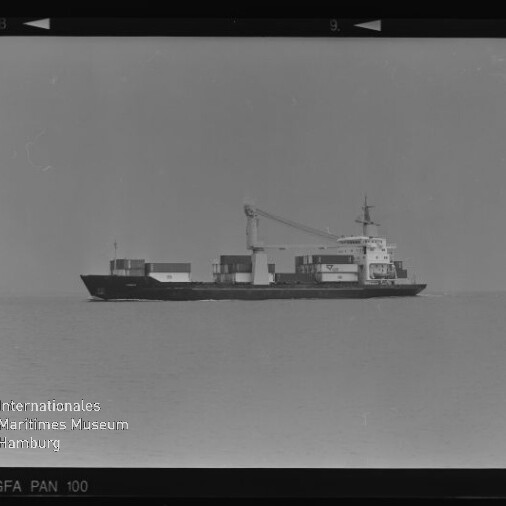 Schwarzweiß-Foto: Seitenansicht eines Containerschiffs mit aufgestapelten Containern und einem großen Ladekran auf ruhiger See vor klarer Horizontlinie.