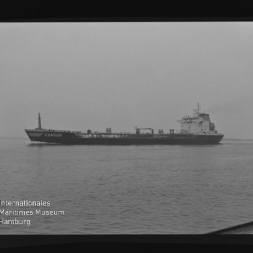Schwarz-weiß-Foto eines Tankschiffs mit dem Namen CONGER in Profilansicht auf ruhigem Wasser unter bedecktem Himmel, mit leichtem Rauch aus dem Schornstein, sichtbarem Filmrand und dem Logo des Internationalen Maritimen Museums Hamburg.