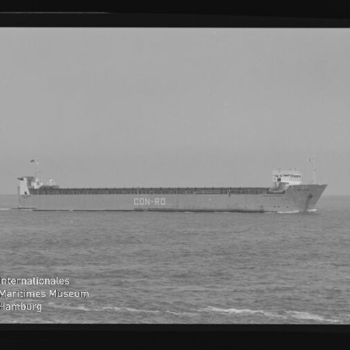 Schwarzweißaufnahme eines langen Frachtschiffs mit der Aufschrift CON-RO am Rumpf, das seitlich auf ruhiger See fährt; Filmrand und Wasserzeichen des Internationalen Maritimen Museums Hamburg sind im Bild sichtbar.