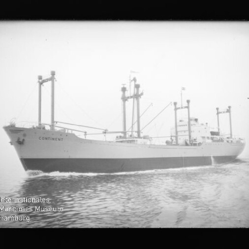 Schwarzweißaufnahme eines Frachtschiffs mit dem Namen CONTINENT, sichtbar sind mehrere Ladebäume, Aufbauten und Bugwellen, im Bild unten links das Wasserzeichen des Internationalen Maritimen Museums Hamburg.