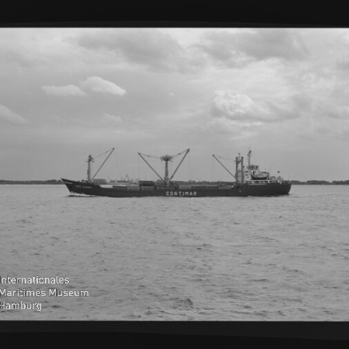 Frachtschiff CONTIMAR mit aufragenden Ladekränen fährt auf ruhiger See unter bewölktem Himmel; im Vordergrund Wasserfläche und links unten das Logo des Internationalen Maritimen Museums Hamburg.