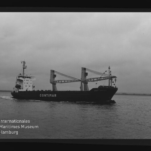 Schwarzweißaufnahme eines Frachtschiffs mit der Aufschrift CONTIMAR und zwei markanten Ladekränen, das bei ruhiger See unter bedecktem Himmel fährt; Filmrand und Logo des Internationalen Maritimen Museums Hamburg sind im Bild sichtbar.