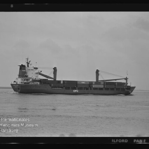 Schwarzweiß-Fotografie eines Frachtschiffs in Seitenansicht auf ruhiger See mit zwei Ladekränen und der Aufschrift „CPC“, sichtbar sind Filmrand und Wasserzeichen des Internationalen Maritimen Museums Hamburg.