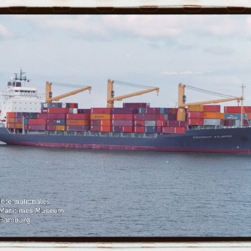 Containerschiff mit gestapelten bunten Containern und drei gelben Ladekränen fährt auf ruhiger See unter hellem Himmel; unten links sichtbares Logo des Internationalen Maritimen Museums Hamburg.