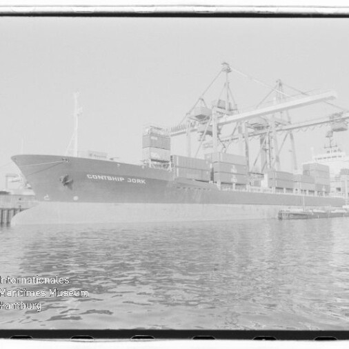 Containerschiff CONTSHIP JORK liegt am Kai eines Hafens unter großen Brückenkränen, gestapelte Container an Deck und ruhiges Wasser im Vordergrund; Stempel Internationales Maritimes Museum Hamburg unten links.
