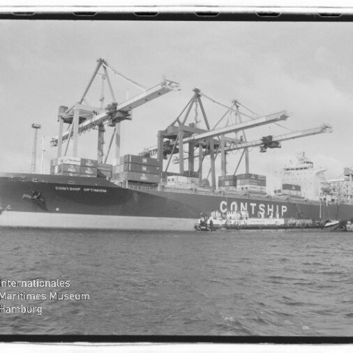 Großes Containerschiff CONTSHIP OPTIMISM am Hafen neben mehreren Auslegerkränen, mit Containern an Deck und Wasser im Vordergrund, Museumswasserzeichen unten links