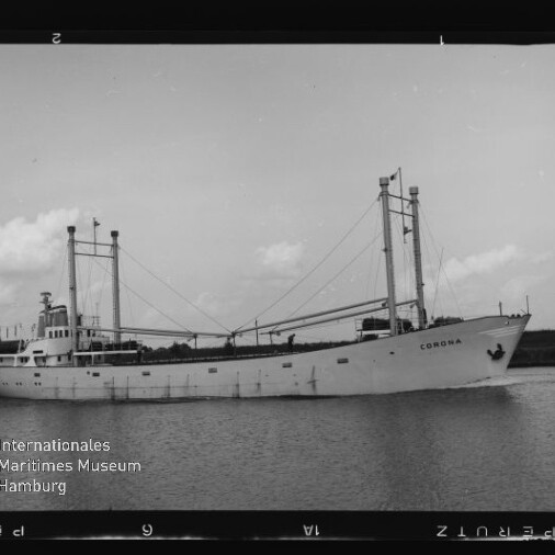 Schwarzweißaufnahme eines weißen Frachtschiffs namens „Corona“ mit zwei Masten und Ladebäumen, das ruhig auf einem Wasserweg vor flachem Ufer fährt; Museumslogo des Internationalen Maritimen Museums Hamburg unten links.