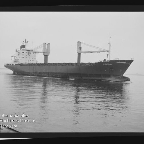 Schwarzweißaufnahme eines Frachtschiffs namens Corona in Seitenansicht auf ruhigem Wasser, mit zwei großen Ladekränen auf dem Deck, sichtbarem Filmrand und der Beschriftung AGFA PAN 100 am rechten Bildrand