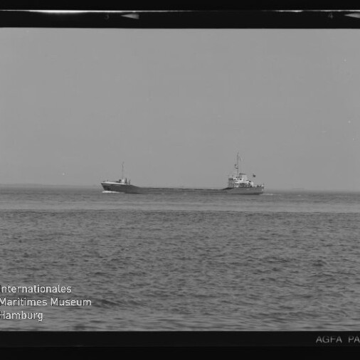 Schwarzweiß-Foto zweier Frachtschiffe auf ruhiger See, leicht versetzt nebeneinander am Horizont, mit sichtbarem Filmrand und dem Wasserzeichen 'Internationales Maritimes Museum Hamburg'.