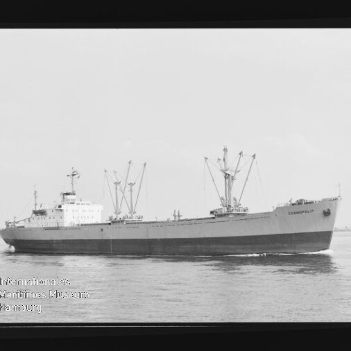 Schwarzweißaufnahme eines Frachtschiffs mit mehreren Ladekränen, das auf ruhiger See fährt; links unten ist das Wasserzeichen des Internationalen Maritimen Museums Hamburg sichtbar.