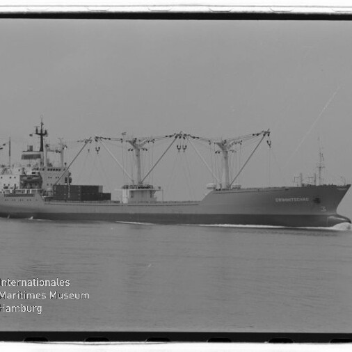 Schwarz-weiß-Foto eines Frachtschiffs mit drei großen Ladekränen, das ruhig über das Meer fährt; links unten Logo und Schriftzug des Internationalen Maritimen Museums Hamburg.
