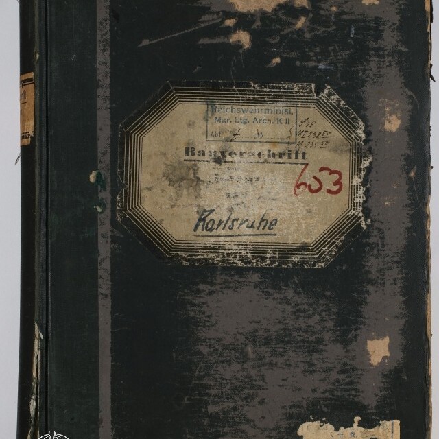 Abgenutztes dunkelgrünes bis schwarzes Buch mit stark abgegriffenem Einband und beschädigten Kanten; mittig ein achteckiges, vergilbtes Etikett mit verblasstem Druck, handschriftlicher Ortsangabe 