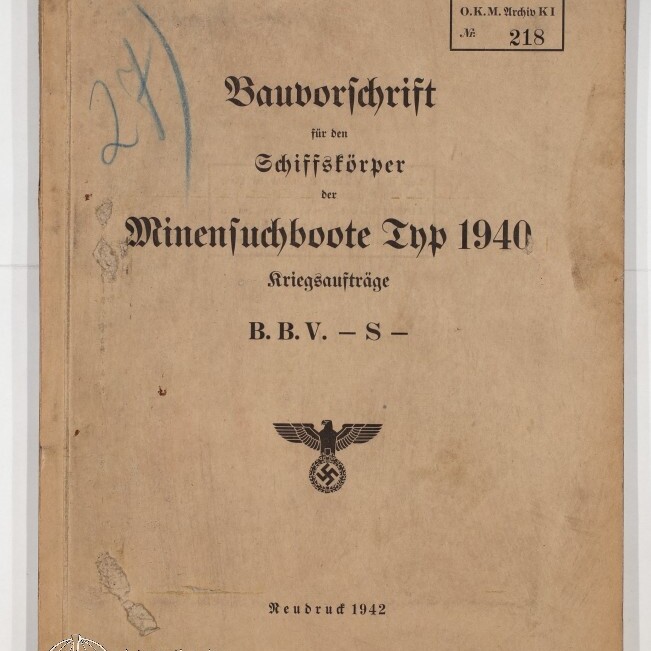 Buchdeckel eines stark gealterten Diensthefts mit dem Titel „Bauvorschrift für den Schiffskörper der Minensuchboote Typ 1940, Kriegsaufträge B.B.V. – S –“, gedrucktem Reichsadler mit Hakenkreuz, handschriftlichen Einträgen, Stempeln und dem Vermerk „Neudruck 1942“