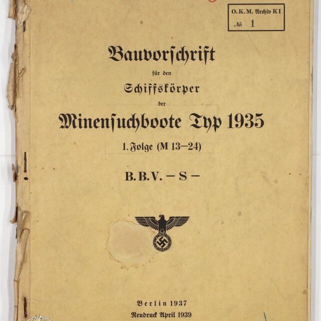 Abgegriffenes beige Deckblatt eines deutschen Marine-Bauvorschriftshefts „Bauvorschrift für den Schiffskörper der Minensuchboote Typ 1935“ (Berlin 1937, Neudruck April 1939), mit gedrucktem NS‑Adler und Hakenkreuz in der Mitte, handschriftlicher roter Nummer „805“ oben, gestempeltem Archivfeld rechts, blau geschriebener Inventarnummer unten und beschädigtem Buchrücken links.