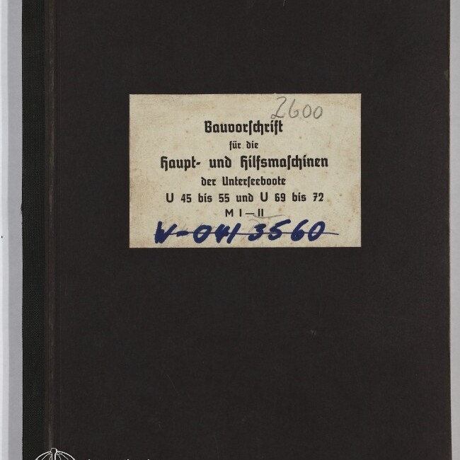 Schwarzer Hardcover-Ordner mit mittig aufgeklebtem rechteckigem Etikett in Frakturschrift mit dem Titel einer Bauvorschrift für U-Boote und handschriftlichen Nummern in Bleistift (2600) und blauer Tinte, unten links das Signet des Internationalen Maritimen Museums Hamburg.