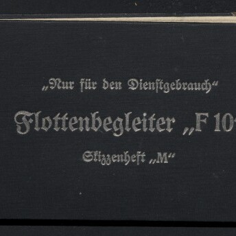 Schwarzes Querformat-Heft mit weißer Frakturschrift ‚Nur für den Dienstgebrauch‘, ‚Flottenbegleiter „F10“‘ und ‚Stimmenheft „M“‘, oben links handschriftliche Zahlen, unten links Logo und Schriftzug des Internationalen Maritimen Museums Hamburg und vereinzelte Flecken auf dem Einband.