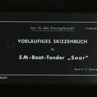Schwarzer Einband eines Hefts mit weißem Rahmen und weißer Aufschrift „VORLÄUFIGES SKIZZENBUCH für SM-Boot-Tender ‚Saar‘“, oben der Hinweis „Nur für den Dienstgebrauch!“, links unten Logo und Schriftzug des Internationalen Maritimen Museums Hamburg; Rücken mit Klebestreifen sichtbar.