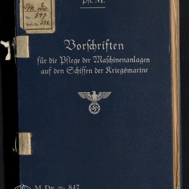 Dunkelblaues Einbandbuch mit silberner Frakturschrift 'Vorschriften für die Pflege der Maschinenanlagen auf den Schiffen der Kriegsmarine', oben die Abkürzung 'Pfl. M.', in der Mitte ein Reichsadler mit Hakenkreuz sowie links oben kleine Etiketten und unten links das Signet des Internationalen Maritimen Museums Hamburg.