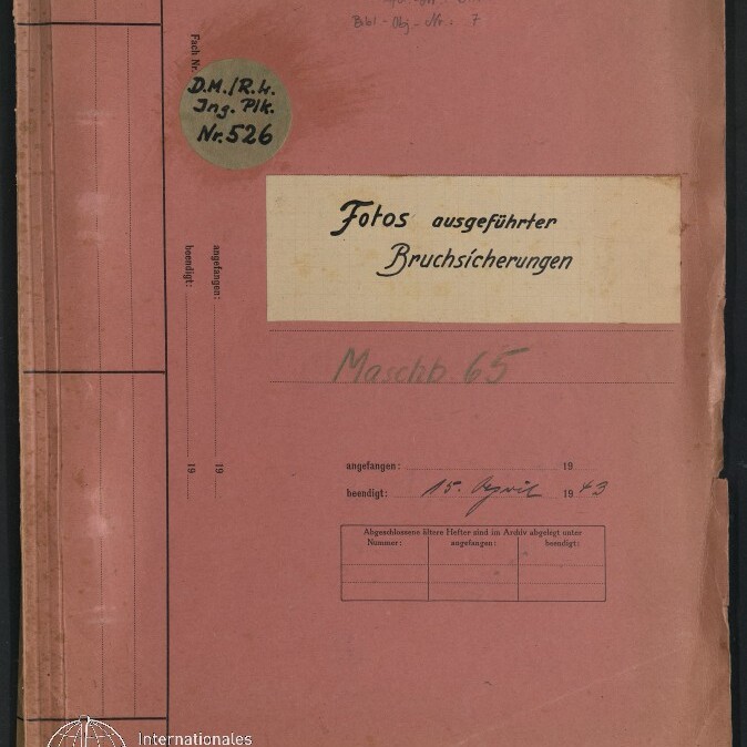 Abgenutztes rosa Aktenheft mit dem Titel 'Fotos ausgeführter Bruchsicherungen' in schwarzer Schrift, einem runden Etikett 'D.M.R.H. Ing. Plk. Nr.526', handschriftlichen Notizen (u. a. 'Maschb.65' und Datum 15. April 1943) sowie dem Logo des Internationalen Maritimen Museums Hamburg in der unteren linken Ecke.