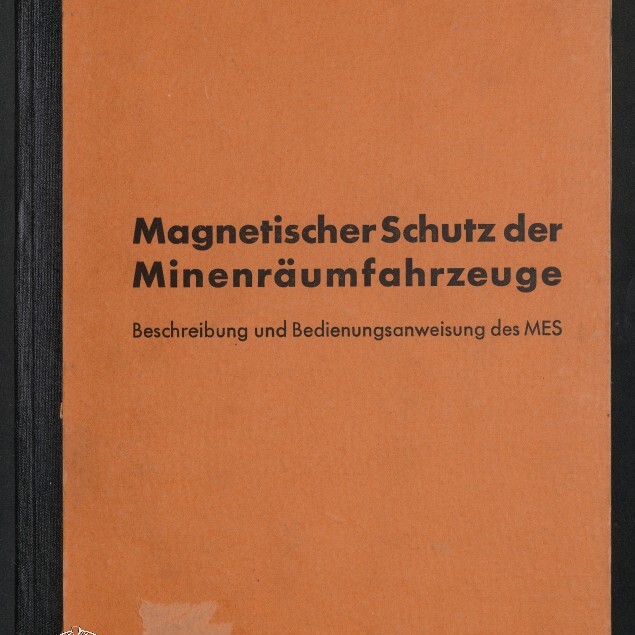 Orangefarbenes Buch mit schwarzem Rücken, großer Titel „Magnetischer Schutz der Minenräumfahrzeuge“ und Untertitel „Beschreibung und Bedienungsanweisung des MES“, oben kleingedruckt „Deutsche Minenräumdienstvorschrift Nr.16“ und unten links Museumssignet mit Hinweis auf das Internationale Maritimes Museum Hamburg.