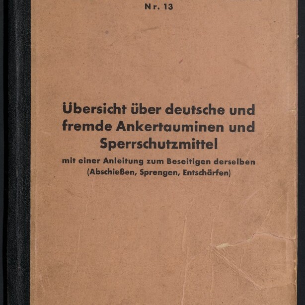 Beige, leicht zerknittertes Buchcover einer deutschen Minenräumdienstvorschrift (Nr. 13) mit schwarzem Rücken, großem Titel „Übersicht über deutsche und fremde Ankertauminen und Sperrschutzmittel“ und Museumslogo unten links