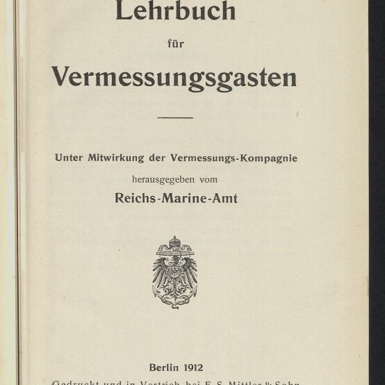 Titelseite eines Buchs mit der Überschrift „Lehrbuch für Vermessungsgasten“, Herausgeberangabe „Reichs-Marine-Amt“, einem kaiserlichen Wappen, der Angabe „Berlin 1912“ sowie einem Stempel/Logo des Internationalen Maritimen Museums Hamburg.