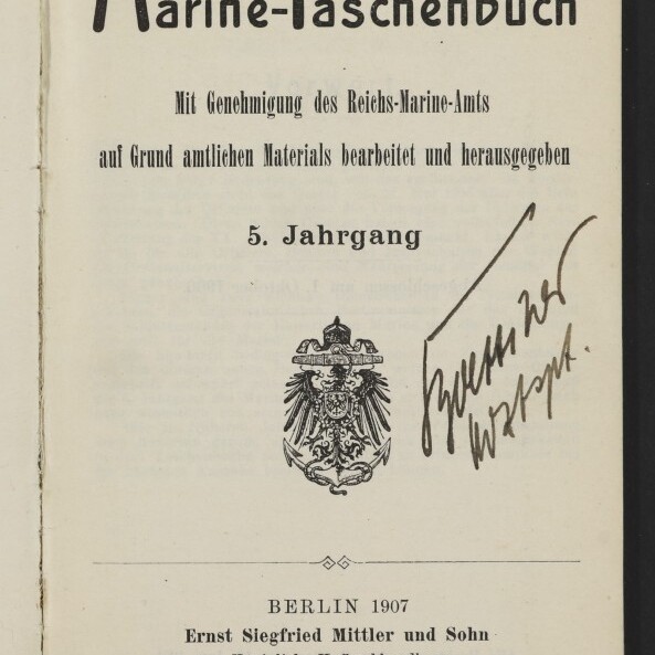 Titelseite eines Buches mit dem Titel „Marine‑Taschenbuch“, darunter gedruckte Angaben „5. Jahrgang“ und Verlagszeile „Berlin 1907, Ernst Siegfried Mittler und Sohn“, ein kaiserlicher Adler als Emblem in der Mitte sowie eine große handschriftliche Signatur rechts; unten links das Logo des Internationalen Maritimen Museums Hamburg.