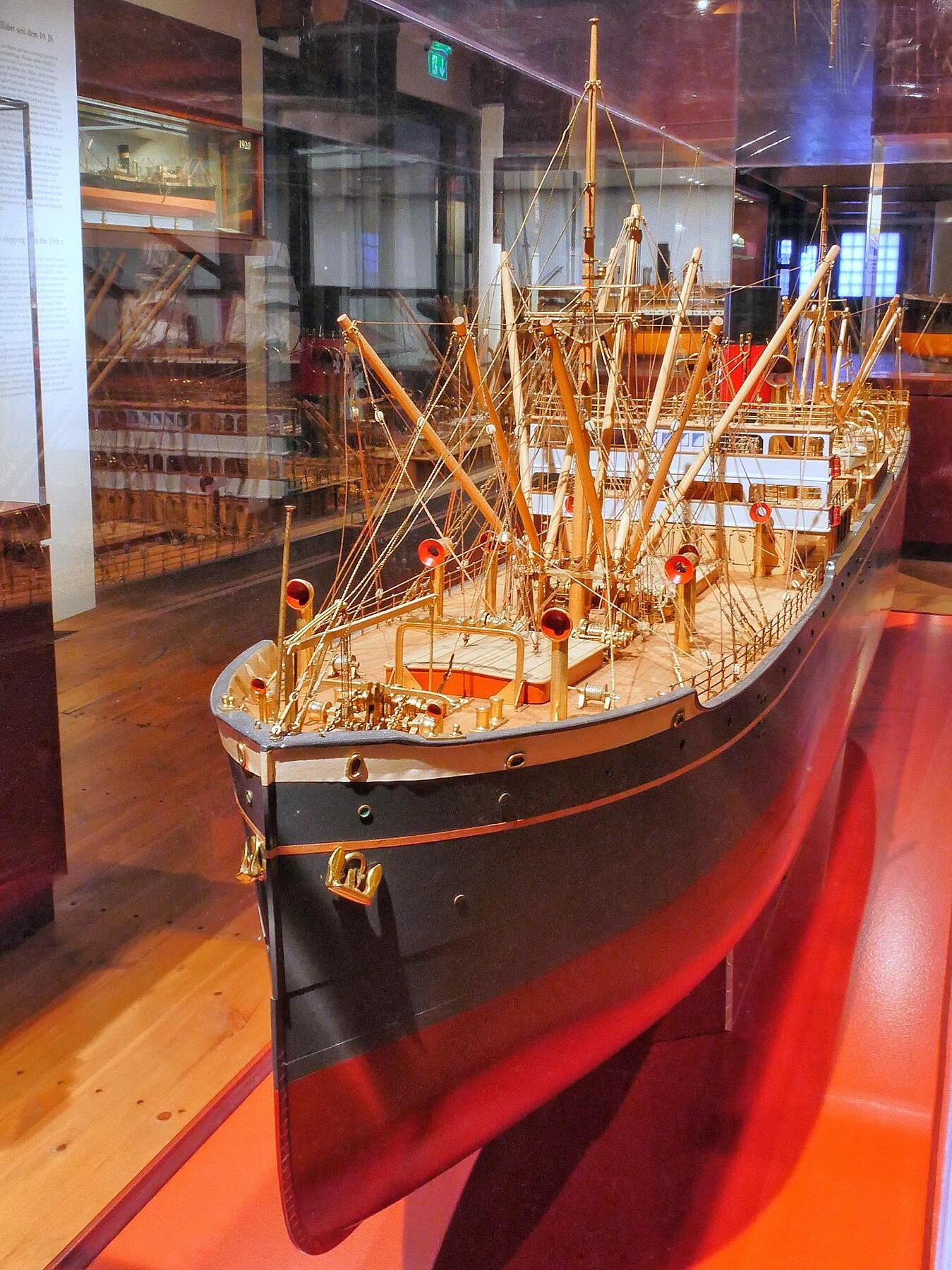 Detailaufnahme eines filigranen Schiffsmodells im Museum mit Masten, Takelage und roten Schornsteinen hinter Glas.