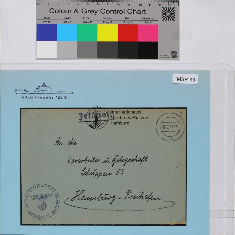 Feldpostumschlag mit handschriftlicher Adresse, NS-Adler-Stempel unten links, Kreisstempel oben rechts und Museumslogo auf hellblauem Hintergrund; Farbkarte oben.