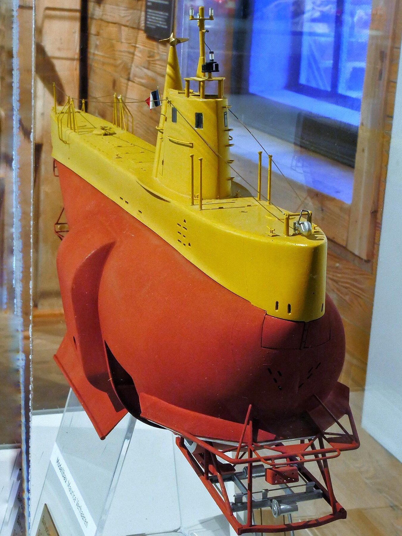 Modell eines roten und gelben Forschungstauchboots mit Turm, Antennen und feinen Relings- und Seil-Details in einer Vitrine