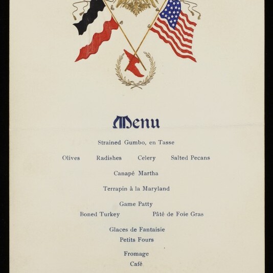Menükarte mit gekreuzten deutschen und US-Flaggen unter goldenem Adlerwappen, listet Gerichte wie Gumbo, Terrapin und Pâté.
