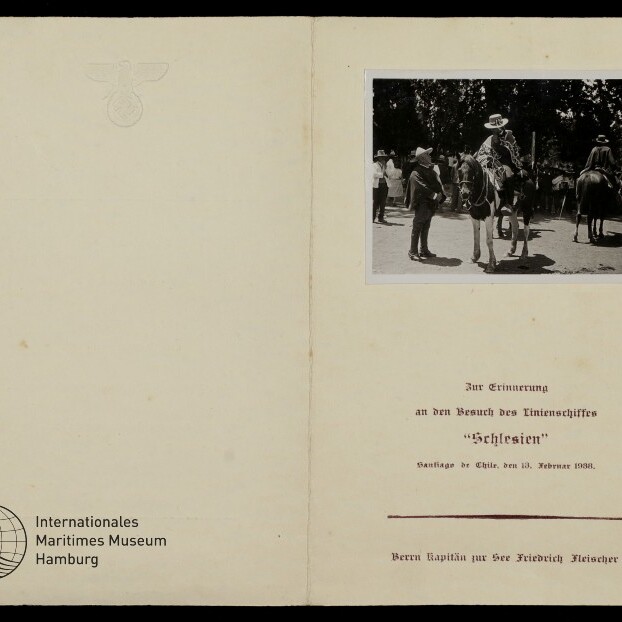 Aufgeschlagenes Heft mit geprägtem Reichsadler, kleines Foto von Reitern und Titel: Besuch des Linienschiffes Schlesien, 12.2.1938.